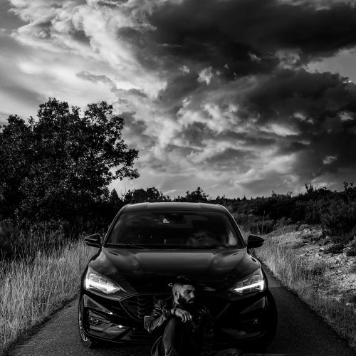 Retrato de hombre con su coche en blanco y negro